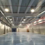 Nave industrial en Sevilla con sistema de iluminación y tuberías contra incendios instaladas por Extintores A2J, combinando eficiencia lumínica y seguridad.