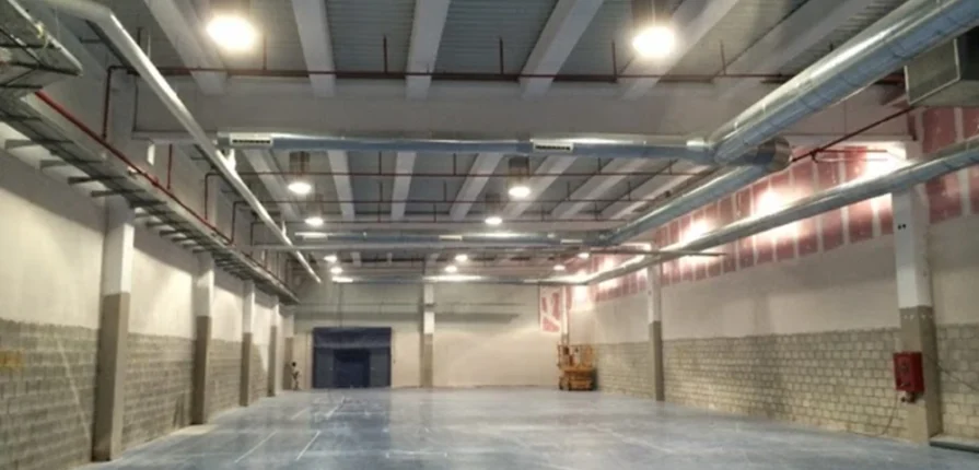 Nave industrial en Sevilla con sistema de iluminación y tuberías contra incendios instaladas por Extintores A2J, combinando eficiencia lumínica y seguridad.