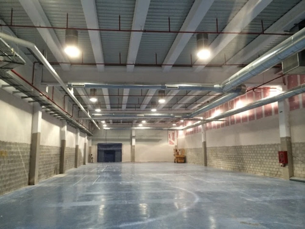 Nave industrial en Sevilla con sistema de iluminación y tuberías contra incendios instaladas por Extintores A2J, combinando eficiencia lumínica y seguridad.